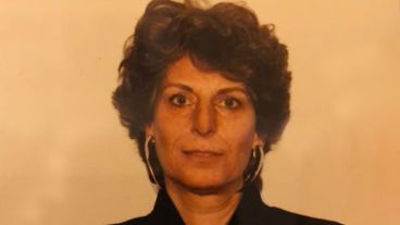 A woman with short, curly brown hair and large silver earrings